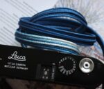 Close up of HOZUMA Blue Mt. Fuji Kumihimo silk camera strap showing braided texture, attached to a black Leica M11 camera.